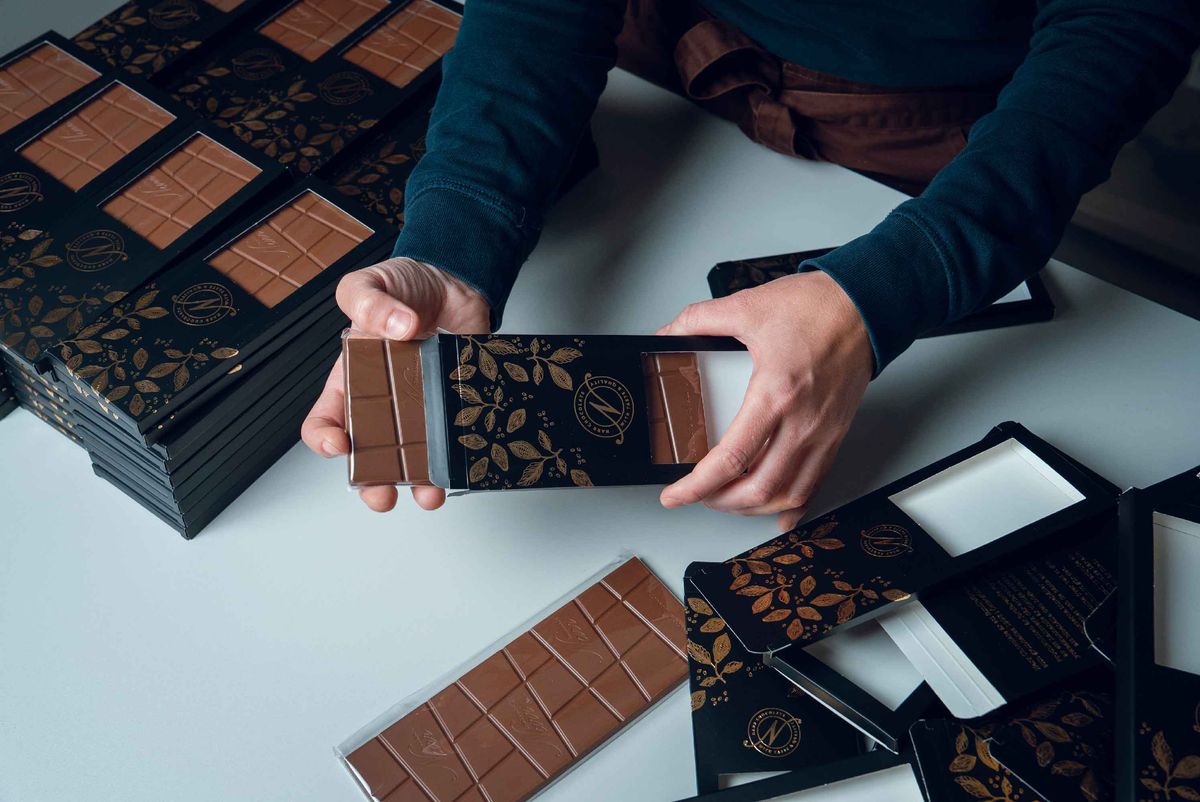 Chokladkakor packas för hand i svarta och guldfärgade förpackningar från Narr Chocolate.